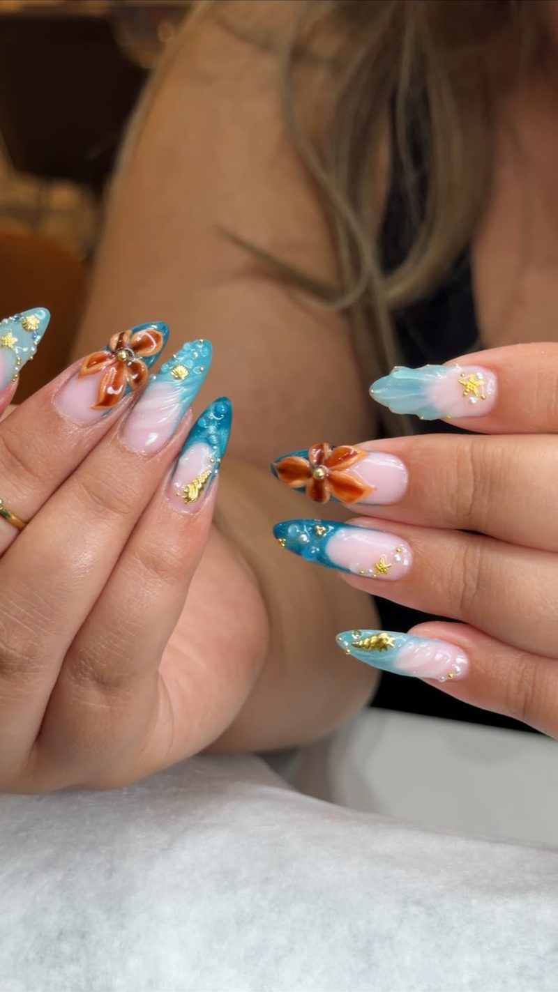 Nail art turquoise et fleurs orange réalisé chez NORITA